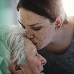 Enkelin küsst Oma auf die Stirn