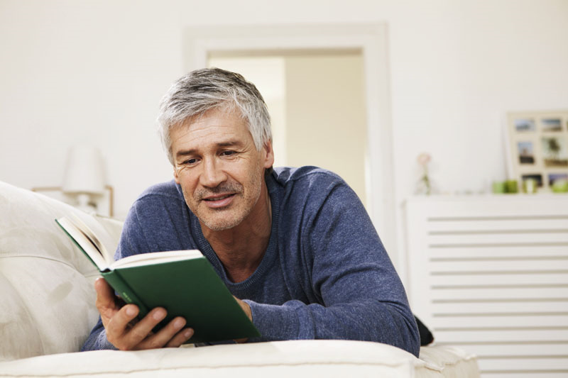 älterer Mann liest einen Buch